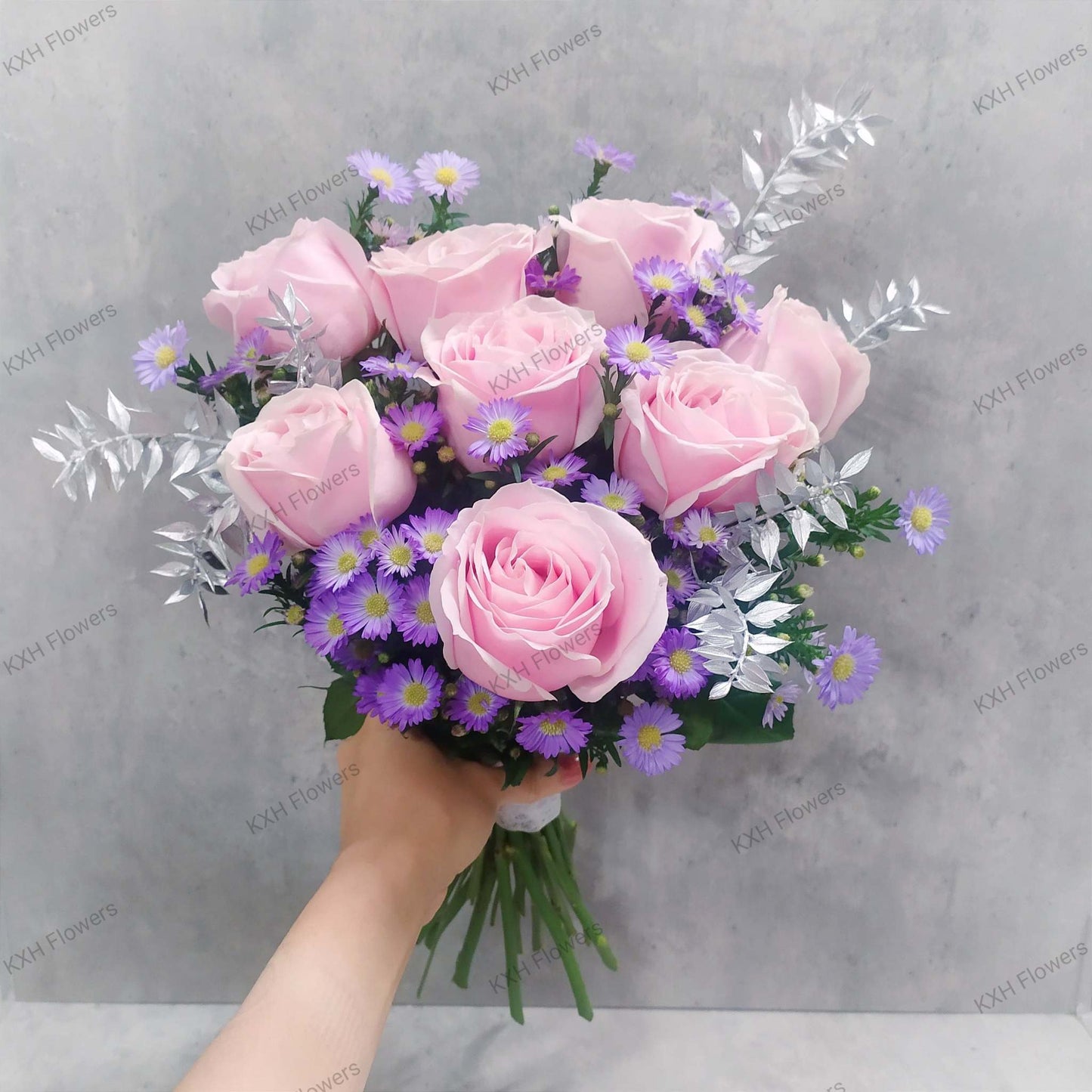 Wrapped bouquet with mixed pink blooms on table