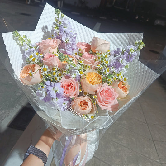 light pink, peach and lilac flowers in white kraft wrapping sg florist singapore flower delivery