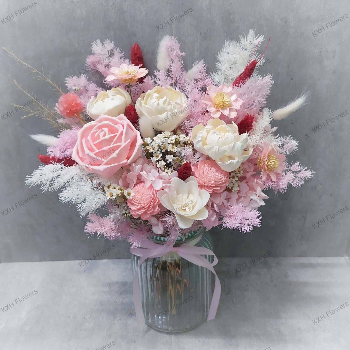 1 pink solawood rose 3 ivory peonies dried daisies preserved hydrangeas and other fillers in a transparent vase singapore florist