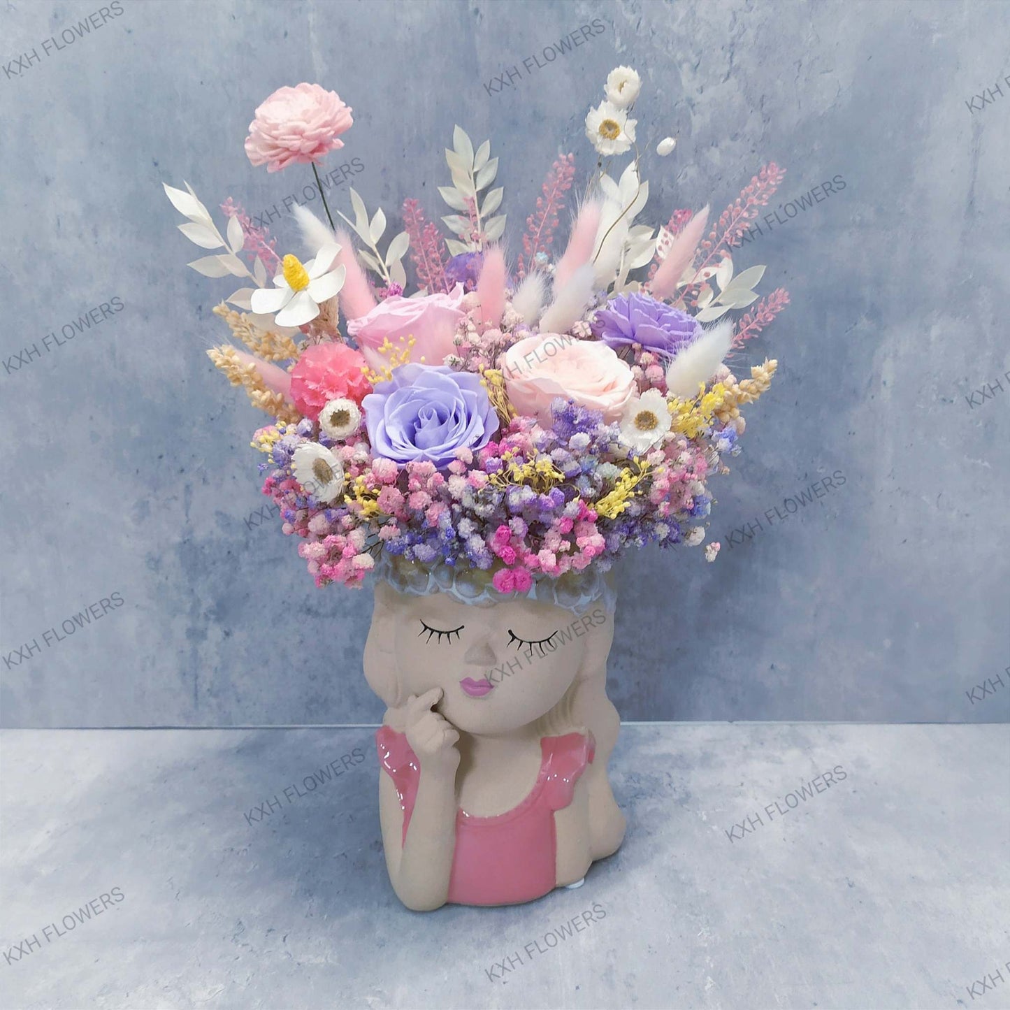 girl thinking preserved roses and dried flowers in unique pink ceramic vase
