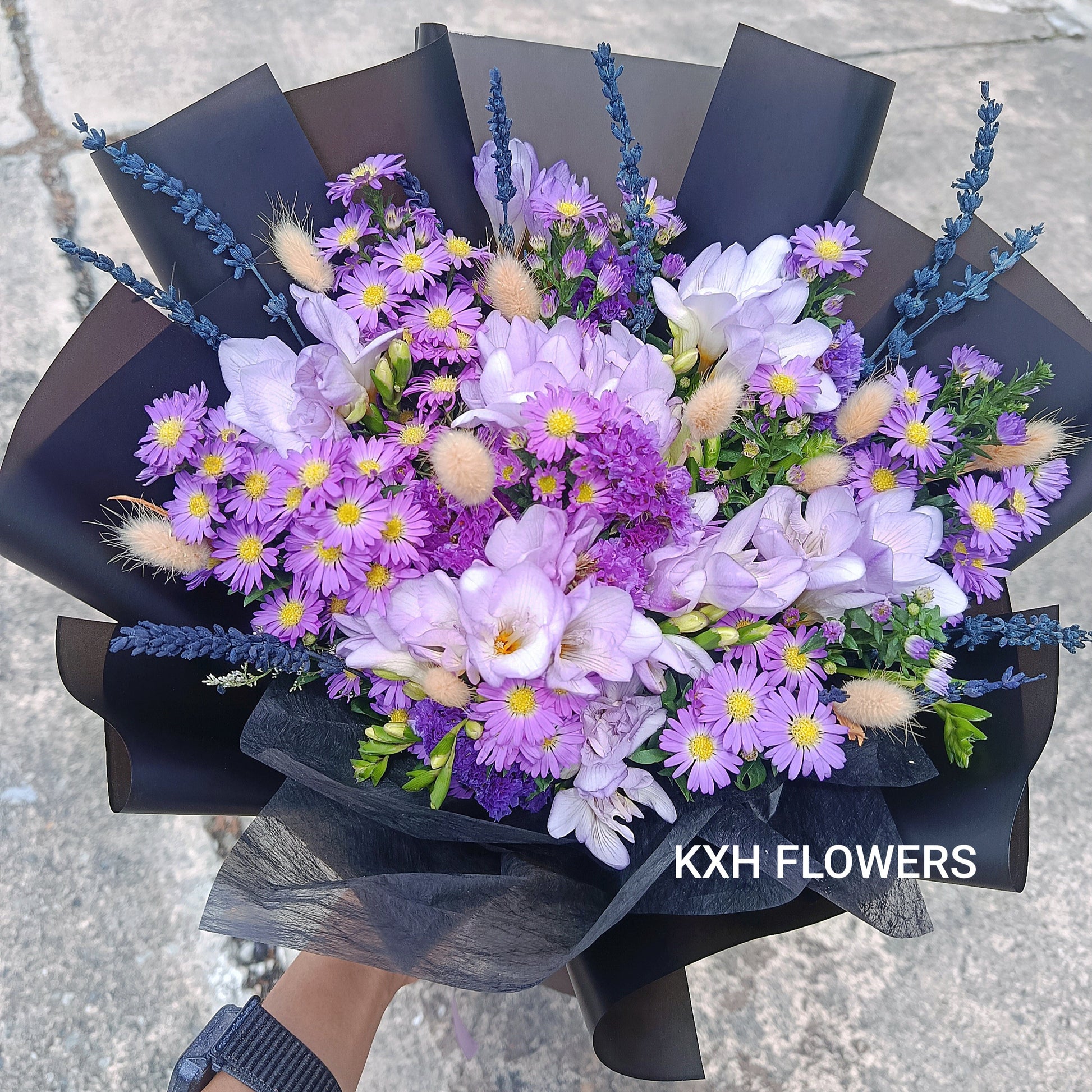 purple freesias with other purple flowers in black wrapping graduation flowers singapore florist delivery