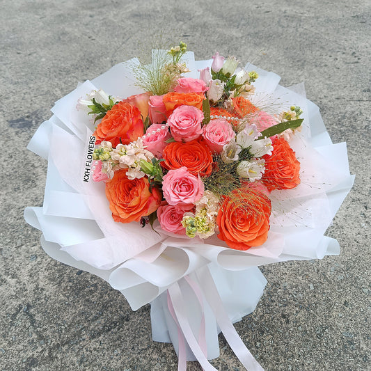 orange roses pink roses peach matthiola white bell flowers fountain grass