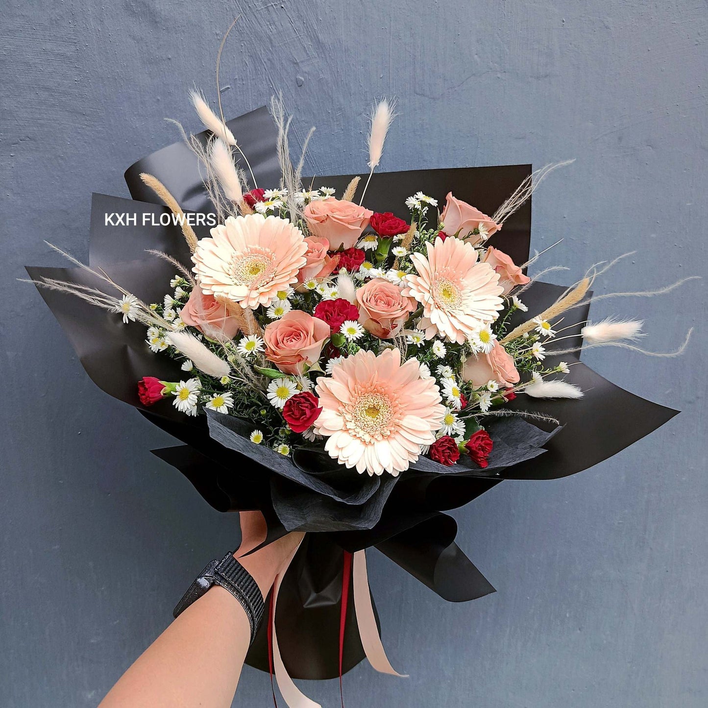 dusty pink cappuccino roses with light peach gerberas mini maroon carnations and mini daisies in black wrapping singapore florist sg delivery flowers for men
