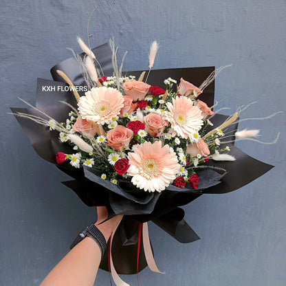 dusty pink cappuccino roses with light peach gerberas mini maroon carnations and mini daisies in black wrapping singapore florist sg delivery flowers for men
