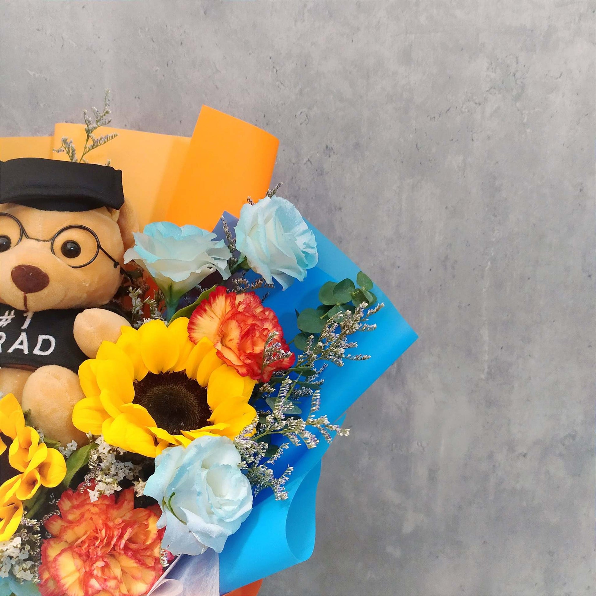 sunflower orange carnations and graduation bear in bouquet