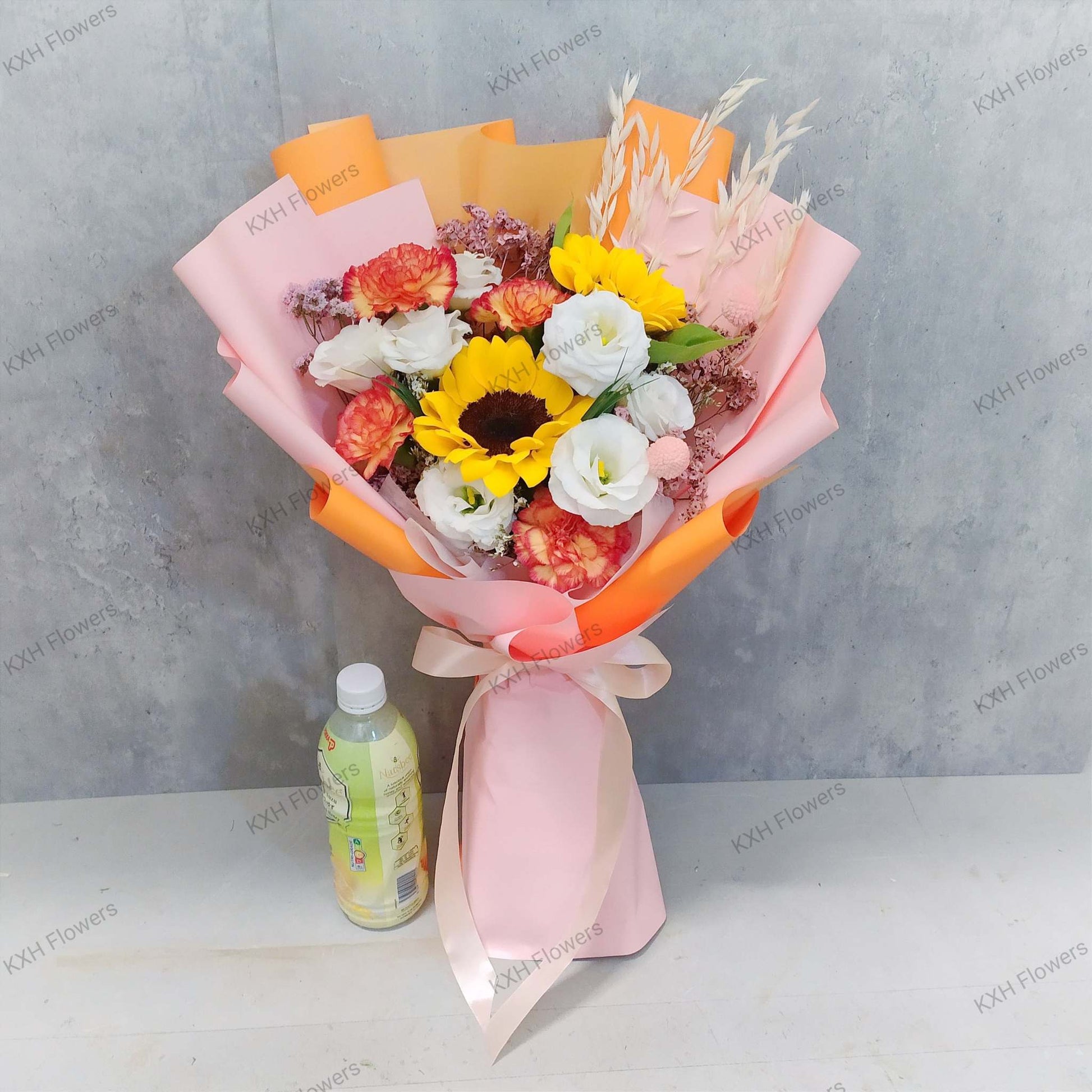 2 sunflowers 4 orange carnations 7 white eustomas graduation bouquet with pink and orange wrapping